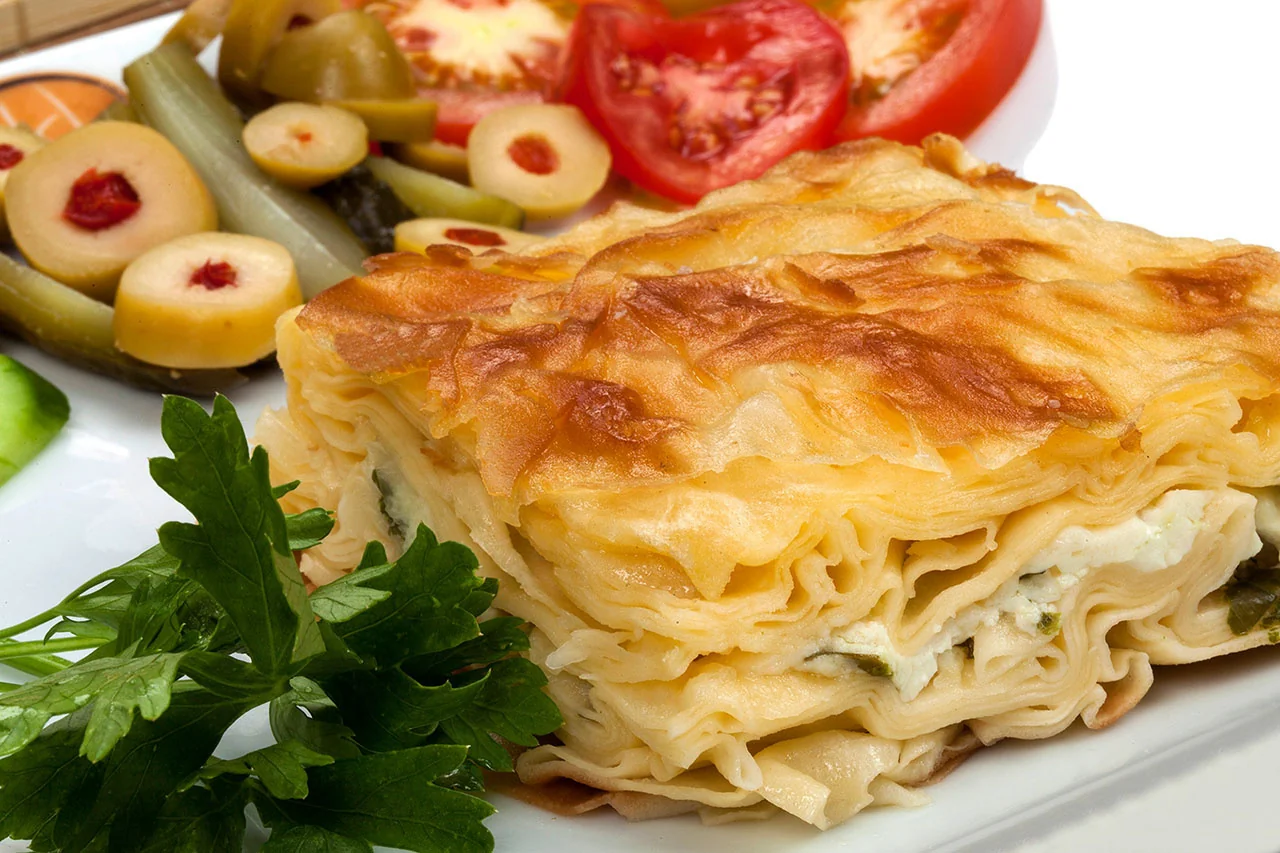 Zeytin ve domates eşliğinde börek dilimleri