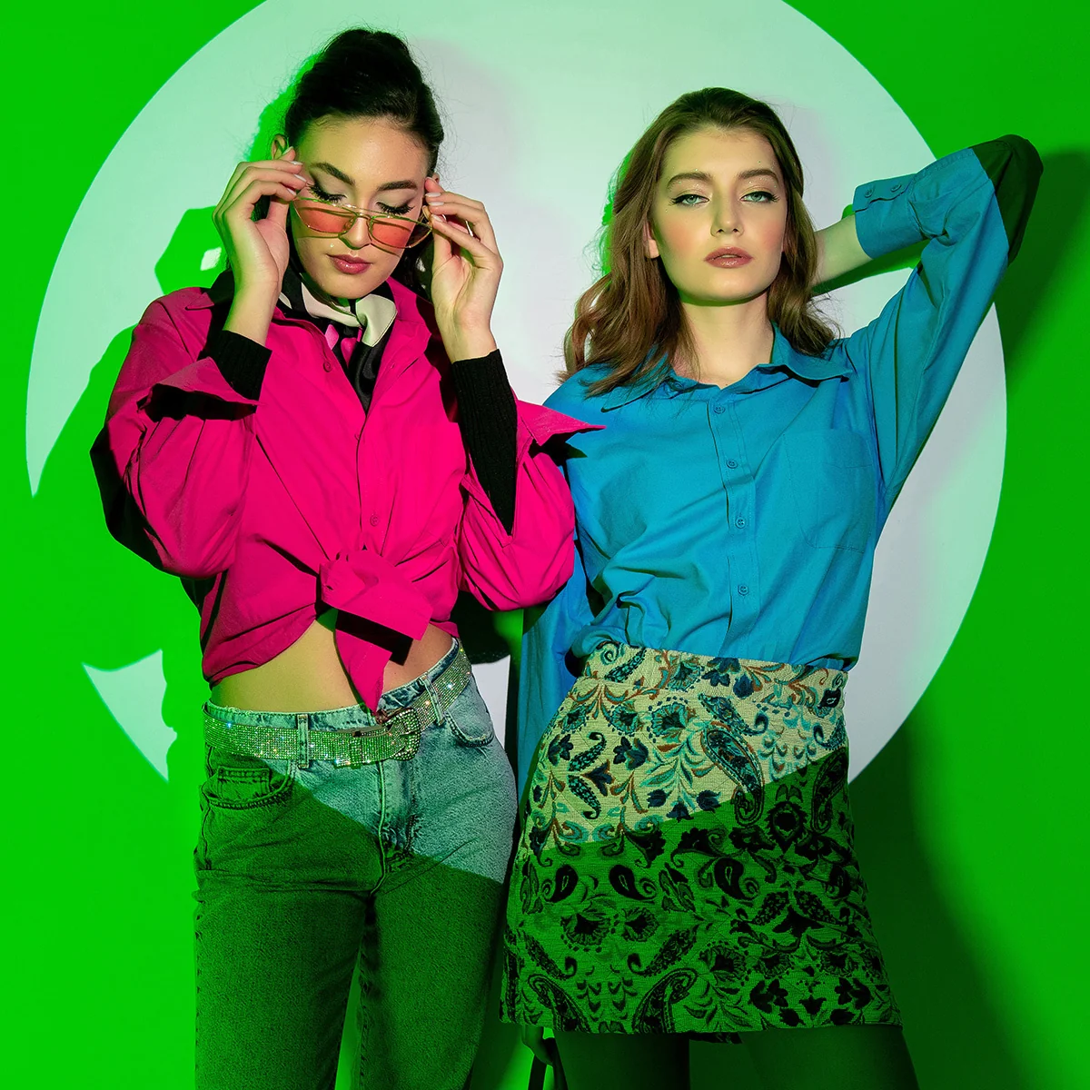 Yeşil fonda iki modelin renkli styling kompozisyonu